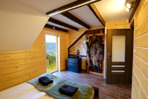 een slaapkamer met houten wanden en een groot raam bij Przystanek Madejowa in Jeleśnia