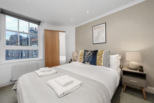 una camera da letto con un letto e due asciugamani di The Old Street Apartment a Londra