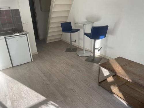 une chambre avec deux chaises bleues et une table dans l'établissement Appartements sympas et confortables, à Nanterre