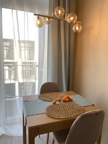 a table with chairs and a table with oranges on it at LeHome Airport Wroclaw in Wrocław