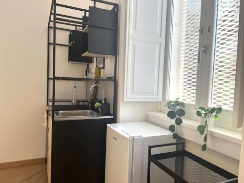 a kitchen with a sink and a black refrigerator at Liberty Villa 2 in Bari