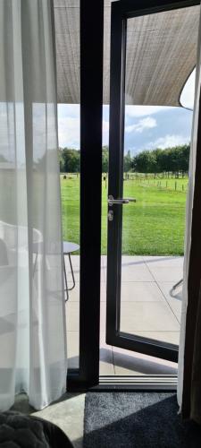 an open door with a view of a field at La Vita Veluwe in Wapenveld