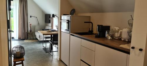 a kitchen with a counter with a refrigerator and a table at La Vita Veluwe in Wapenveld