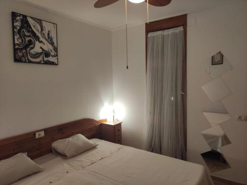 ein Schlafzimmer mit einem Bett, einer Lampe und einem Fenster in der Unterkunft La Dolce Casa in Costa Del Silencio