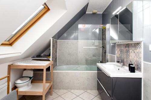 a bathroom with a bath tub and a sink at L’Albizia … Maison familiale proche des plages in Plougoulm