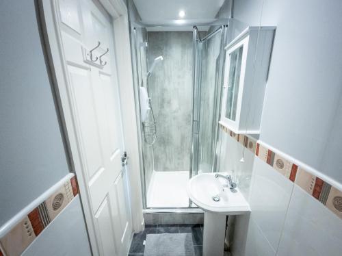 a small bathroom with a shower and a sink at Tranquil 2Bed/2Bath Duplex Falkirk in Falkirk