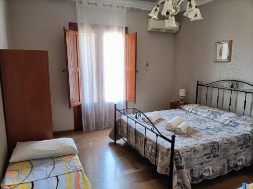 a bedroom with two beds and a window at Appartamento Achiazza Scala dei Turchi in Realmonte