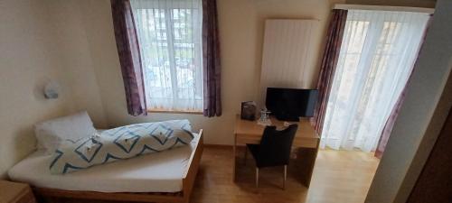 a living room with a couch and two windows at Hotel / Restaurant Post in Eschlikon