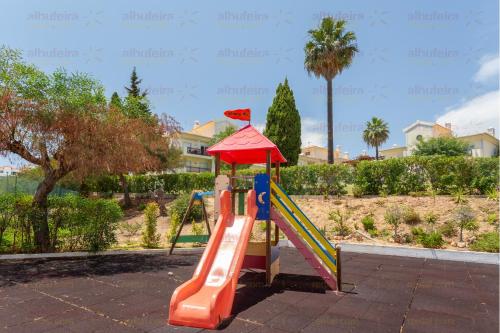 um parque infantil com escorrega num parque em Jardins de Santa Eulália By Albufeira Rental em Albufeira