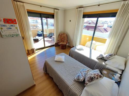 a bedroom with two beds and a large window at Algarve 360º Experience in Campina de Cima