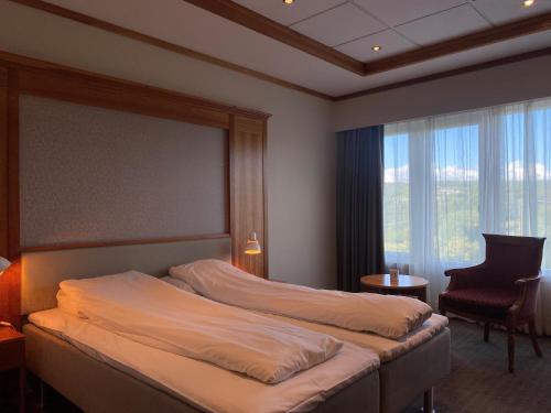 AlversundにあるAlver Hotelのベッドルーム1室(ベッド1台、椅子、窓付)