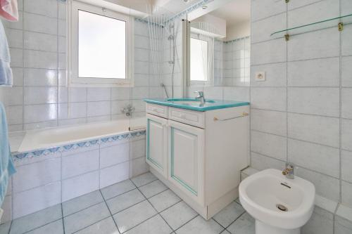 une salle de bain avec toilettes, lavabo et baignoire dans l'établissement Le 11 - Appt climatisé avec piscine partagée, à Saint-Raphaël