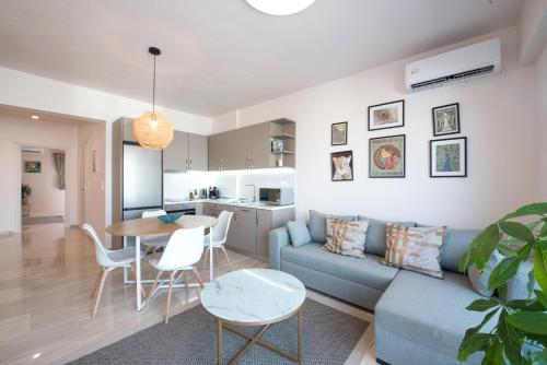 un soggiorno e una cucina con divano e tavolo di Daphne by halu! : Downtown family penthouse a Salonicco