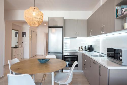 a kitchen with a wooden table and white chairs at Daphne by halu! : Downtown family penthouse in Thessaloniki