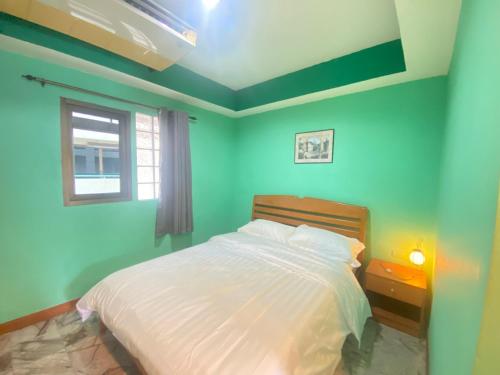 a bedroom with a white bed with a window at 21 hotel in Pattaya