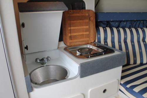 a small kitchen with a sink in a caravan at Barco Frapé in Barcelona