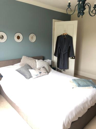 a bedroom with two beds and a suit hanging in a mirror at Balcarres, Rodborough Avenue in Stroud
