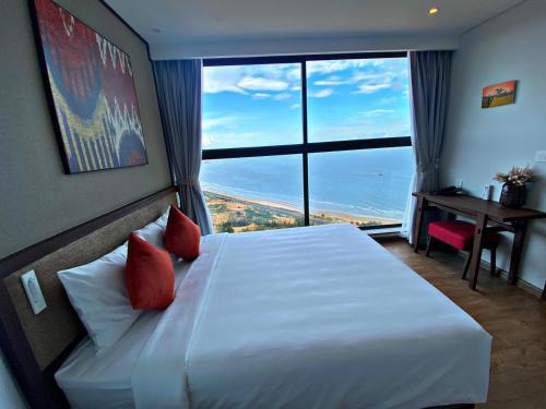 a hotel room with a bed with a large window at Mandala Casa del Sol Mũi Né in Mui Ne