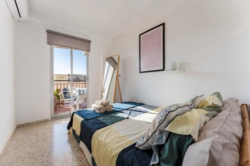 a bedroom with a bed in a room with a balcony at Apartamento Arco Iris in Fuengirola