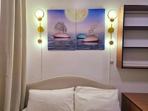 a bedroom with a bed and two paintings on the wall at Acellyne Suites at Green 2 Residences with Netflix! in Dasmariñas