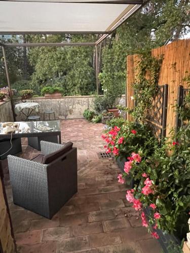 a patio with a table and chairs and flowers at Atelier Fuori Città in Perugia