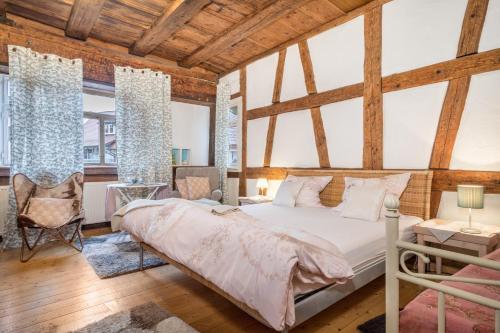 - une chambre avec un grand lit dans une pièce dotée de plafonds en bois dans l'établissement Lemkamp klein, à Markdorf