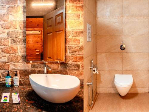 a bathroom with a white sink and a toilet at Treebo Rock Valley in Ponda