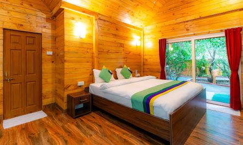 1 dormitorio con 1 cama en una habitación de madera en Treebo Trend Rock Valley en Ponda