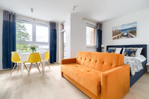 a bedroom with a couch and a bed and a table at Your Holidays Bel Mare Aqua in Międzyzdroje