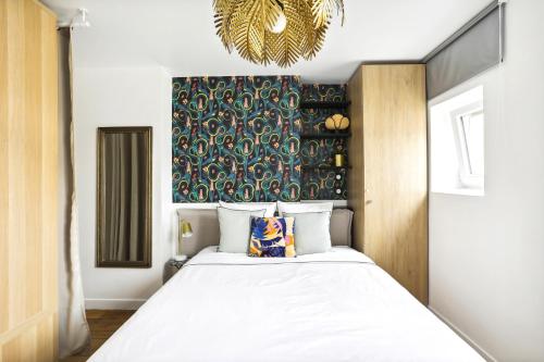 a bedroom with a large bed and a chandelier at PL1 - Stylish architect studio near Le Marais in Paris