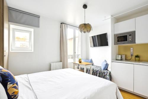 une chambre blanche avec un lit et une cuisine dans l'établissement Luxury architect studio near Le Marais, à Paris