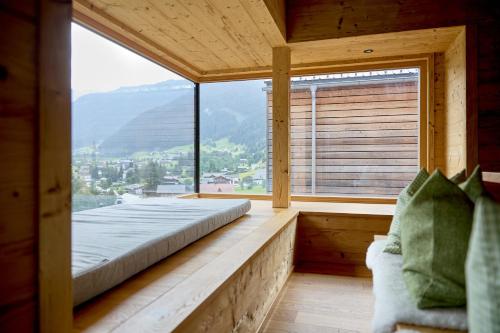 a bedroom with a bed and a large window at DESIGN-CHALETS by Pferd auf Wolke NEU in Gaschurn