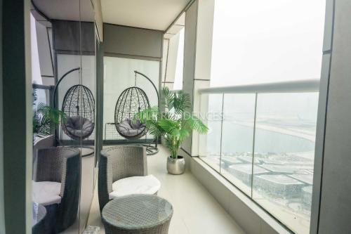 a balcony with chairs and a table and a window at Quill Residence at Paramount Towers 3 BR Creek View in Dubai