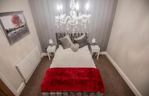 a bedroom with a large bed with a red blanket at The George Wright Boutique Hotel, Bar & Restaurant in Rotherham