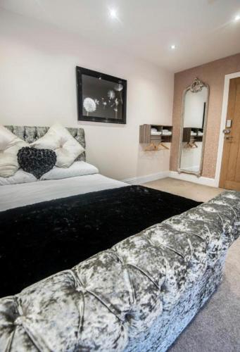 a bedroom with a large bed and a mirror at The George Wright Boutique Hotel, Bar & Restaurant in Rotherham