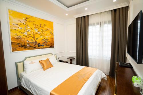a bedroom with a bed and a painting on the wall at Hotel Trung Duong in Móng Cái