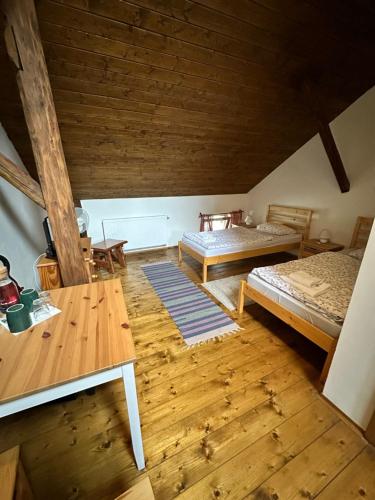 an attic room with two beds and a table at Slezský Grunt in Háj ve Slezsku