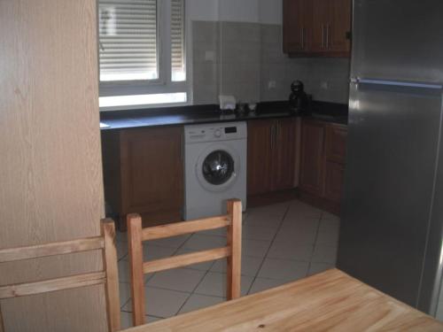 cocina con lavadora y mesa en Bien situé T4 à Oran, en Orán