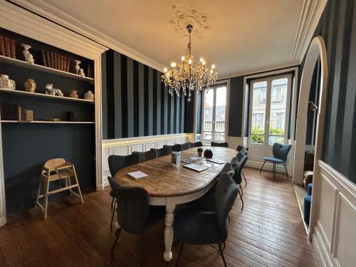 a dining room with a table and chairs and a chandelier at Villa Dei 15pers SPA Baby-foot 20min Mer in Villedieu-les-Poêles