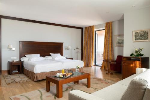 ソリアにあるパラドール デ ソリアのベッドとリビングルームが備わるホテルルームです。