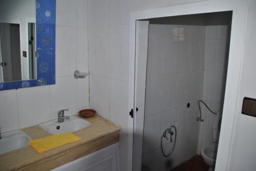 a white bathroom with a sink and a shower at Ferme Dar Aicha green Bellouta in Bellouta