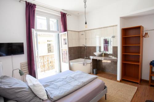 a bedroom with a bed and a bathroom with a sink at Private Room & Private Bathroom - Historic Center in Béziers