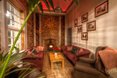 a living room with couches and a clock on the wall at The George Wright Boutique Hotel, Bar & Restaurant in Rotherham