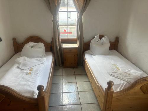 two twin beds in a room with a window at Gasthof zur Post in Siegen