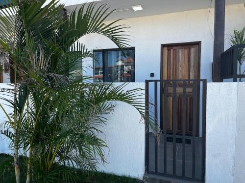 a house with a black gate and some plants at Meu Loft Barra Nova 3 in Saquarema