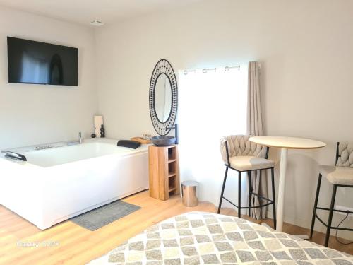 a room with a bath tub and a table and chairs at Ame O des Flandres, La Suite in Boeschèpe