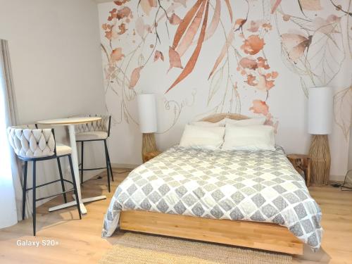 a bedroom with a bed and a table and chairs at Ame O des Flandres, La Suite in Boeschèpe
