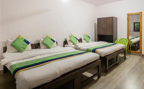 a room with two beds and a mirror at Treebo Rock Valley in Ponda