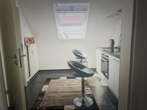 a kitchen with two stools in a room with a window at Boutique Art80 Apartment in Mülheim an der Ruhr