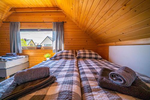 ein Schlafzimmer mit einem Bett in einem Blockhaus in der Unterkunft Wichrowe Domki Plus in Władysławowo